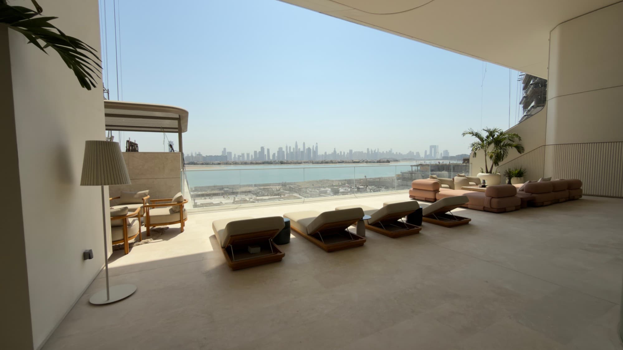 The terrace, with loungers facing the Dubai skyline across the water