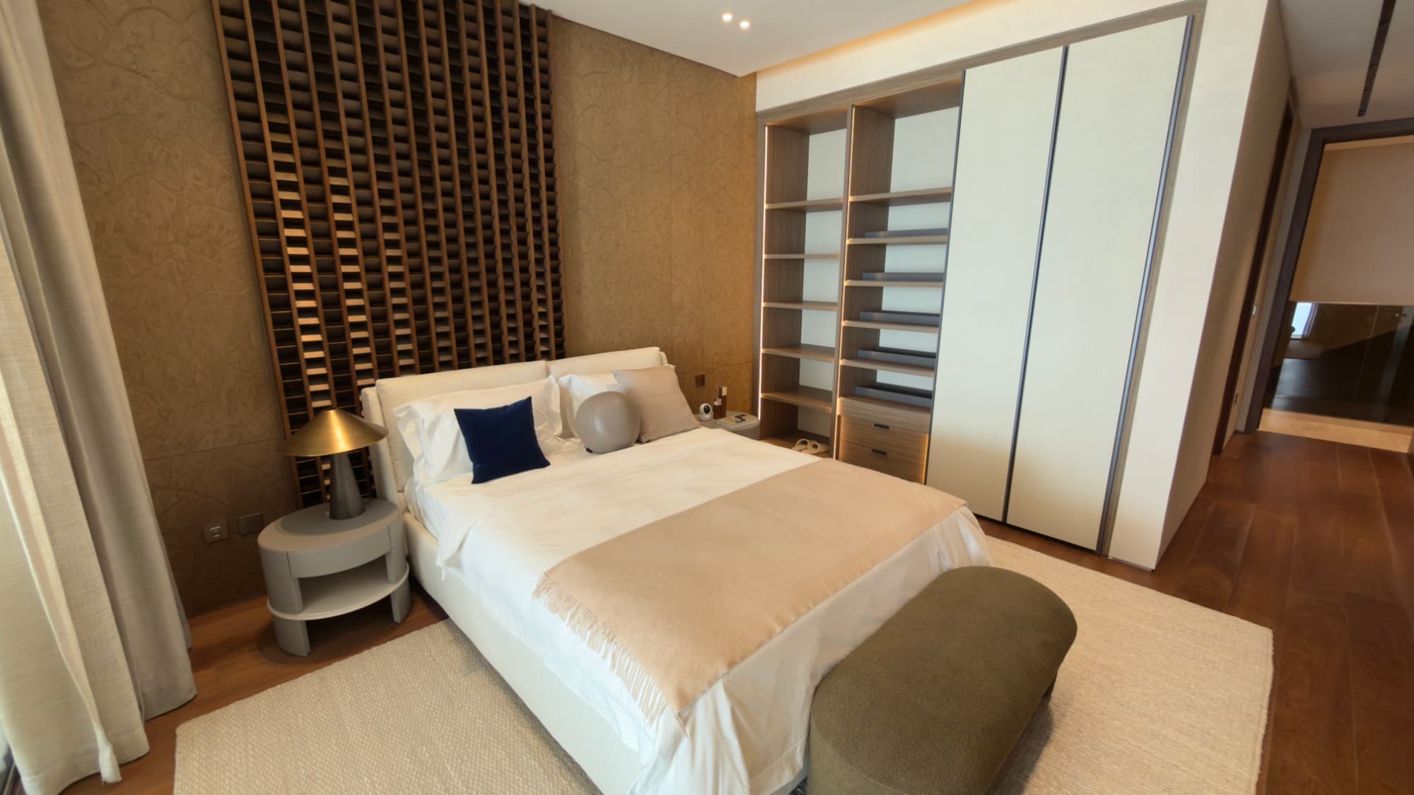 A bedroom suite with a slatted timber headboard and fitted wardrobes